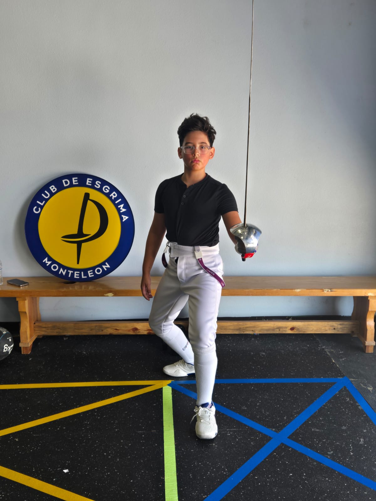 Fencer posing beside the Monteleón logo