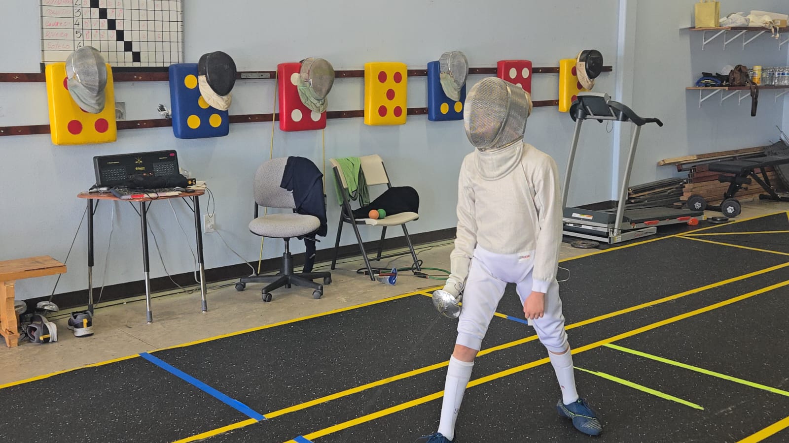 Young fencer on guard in full gear