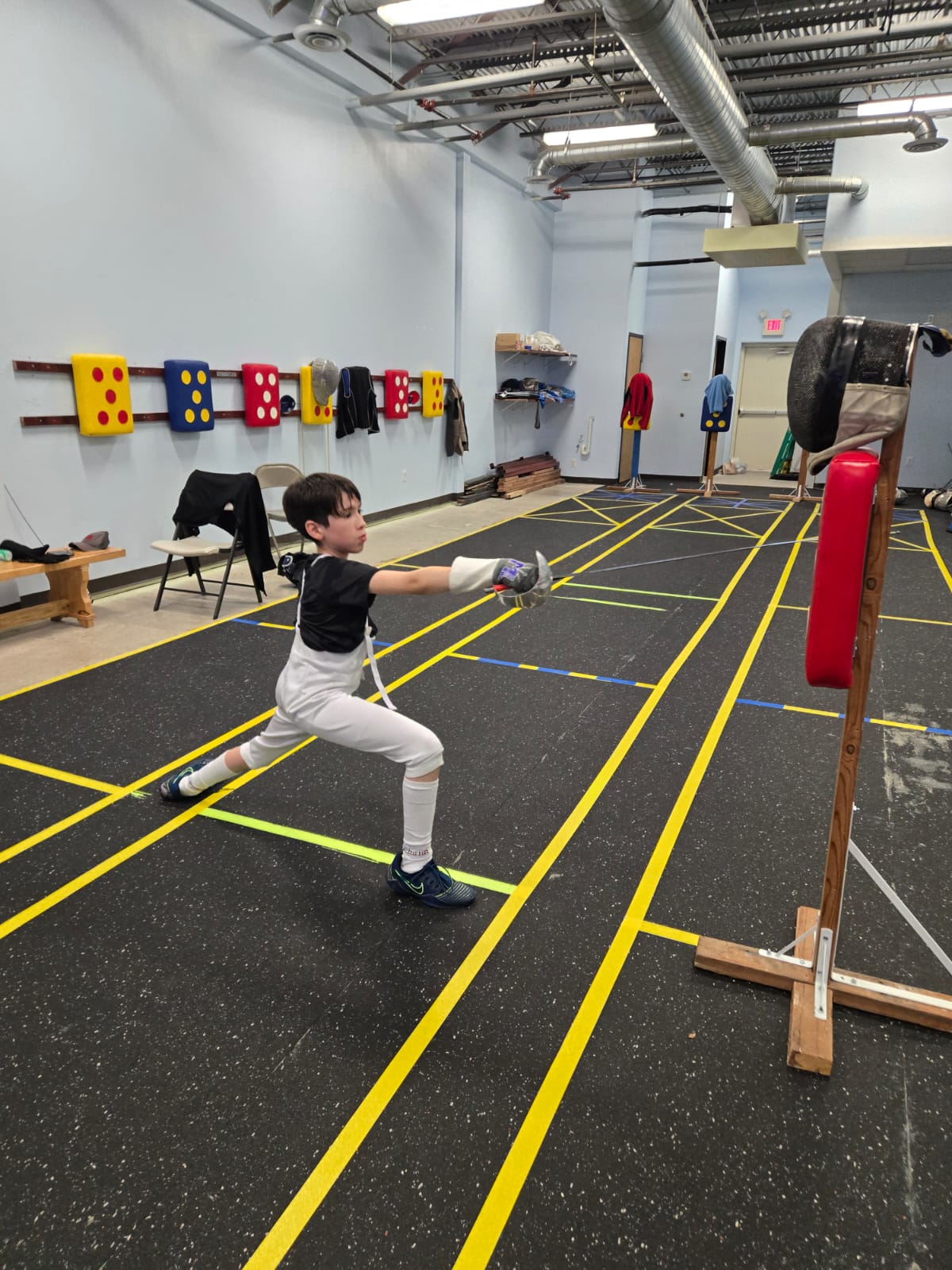 Youth fencer attacking a target
