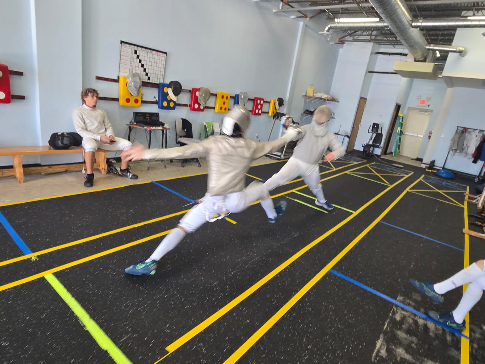 Fencers lunging in a bout